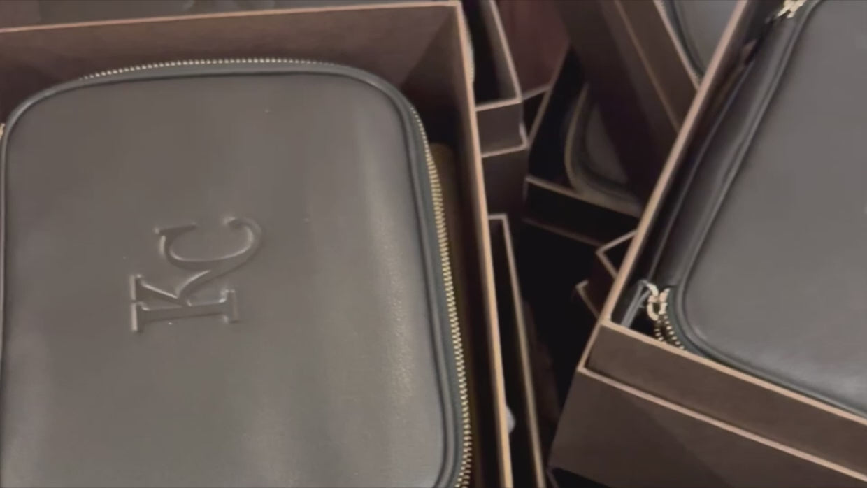 Load video: Video depicting travel organizers being stamped with a monogram and a KC logo.